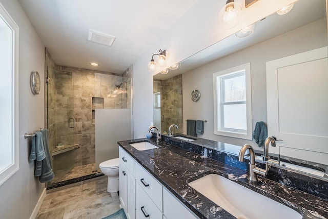 bathroom featuring walk in shower, vanity, and toilet