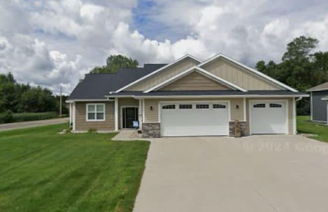 craftsman inspired home with a garage and a front yard