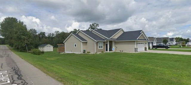 view of front facade with a garage, a storage unit, and a front lawn