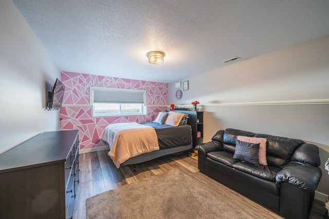 bedroom with a textured ceiling and dark hardwood / wood-style flooring