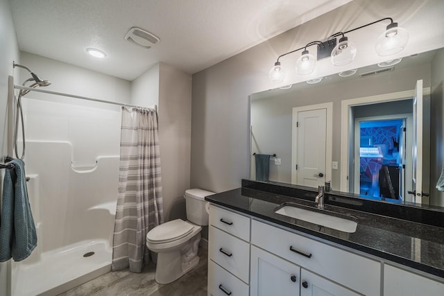 bathroom with vanity, toilet, a textured ceiling, and a shower with curtain