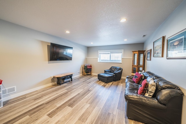 living room featuring a textured ceiling and light wood-type flooring