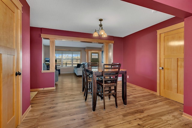 dining room with ornate columns and wood-type flooring