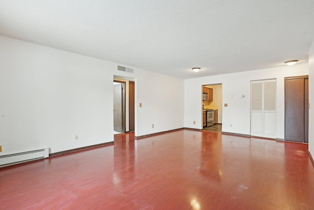 unfurnished room featuring hardwood / wood-style flooring and a baseboard heating unit