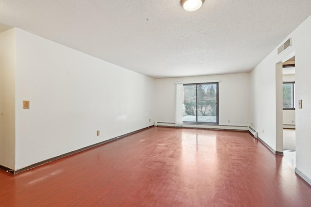 unfurnished room with a textured ceiling and baseboard heating