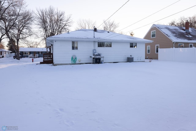 snow covered back of property featuring cooling unit