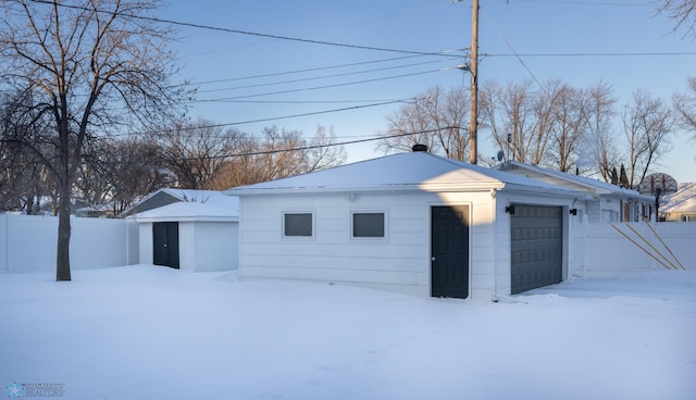 view of front of home with a garage and an outbuilding