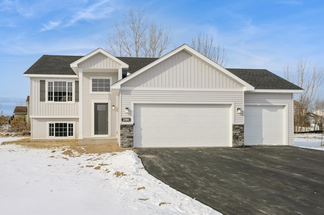 view of front of property with a garage, aphalt driveway, roof with shingles, and board and batten siding