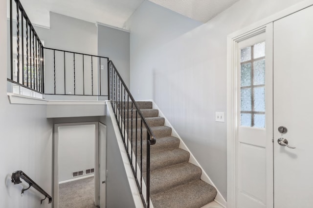 stairs featuring carpet flooring