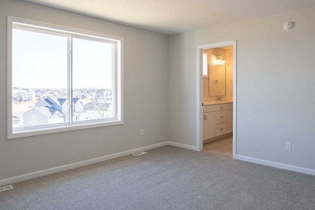 unfurnished room featuring light colored carpet, visible vents, and baseboards