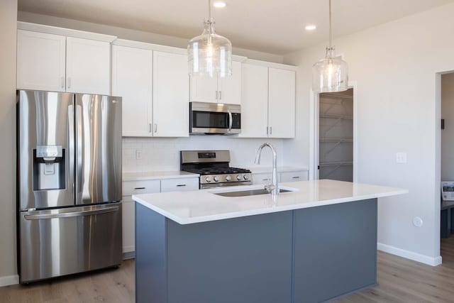 14554 Kingsview Ln N, Dayton, MN 55327 - kitchen with appliances with stainless steel finishes, a sink, light wood-style flooring, a kitchen island with sink, and recessed lighting