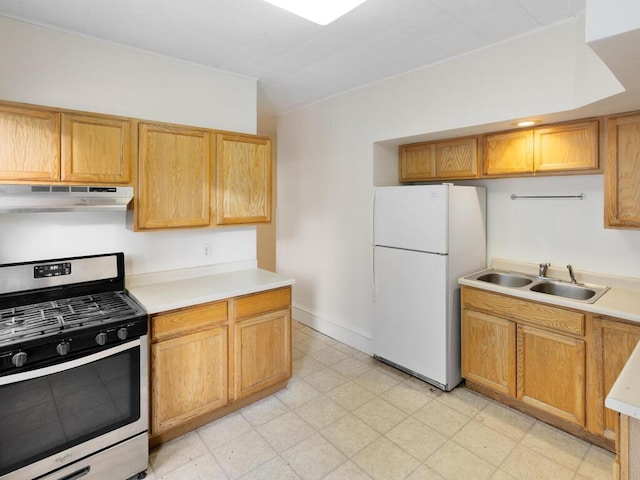 kitchen with white refrigerator, sink, and stainless steel gas stove