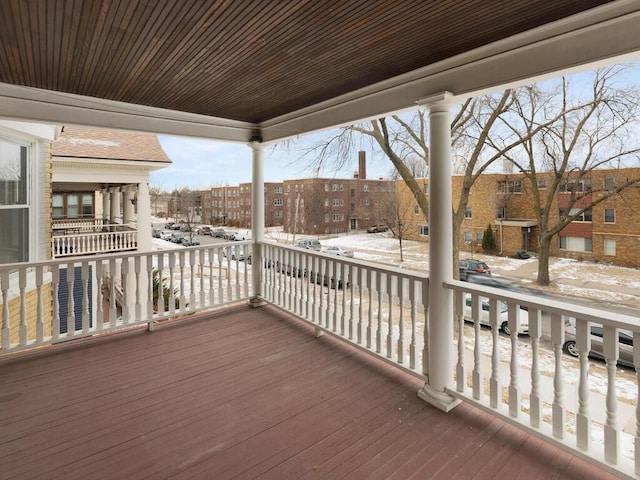 snow covered deck featuring a porch