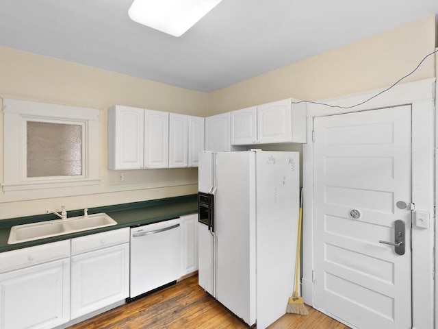 kitchen featuring white cabinetry, white appliances, dark hardwood / wood-style floors, and sink