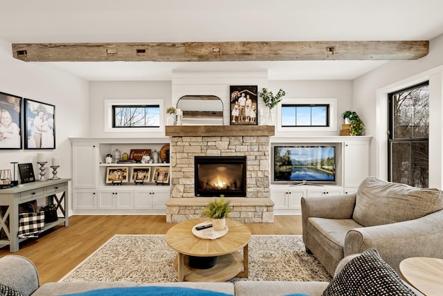 living room featuring a stone fireplace and light hardwood / wood-style floors