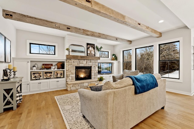 living room with a fireplace, light hardwood / wood-style flooring, and beamed ceiling