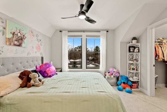 bedroom with lofted ceiling, ceiling fan, carpet floors, a walk in closet, and a closet