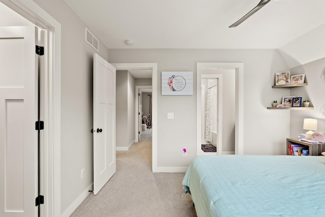 carpeted bedroom with ceiling fan, lofted ceiling, and ensuite bath