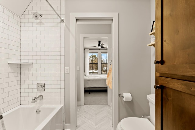 bathroom with tiled shower / bath combo and toilet