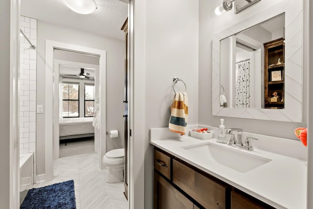 full bathroom featuring shower / bathtub combination with curtain, vanity, toilet, and a textured ceiling