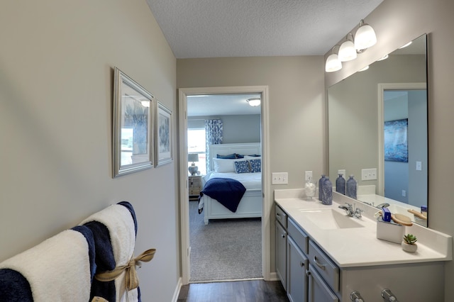 bathroom featuring wood-type flooring, a textured ceiling, and vanity