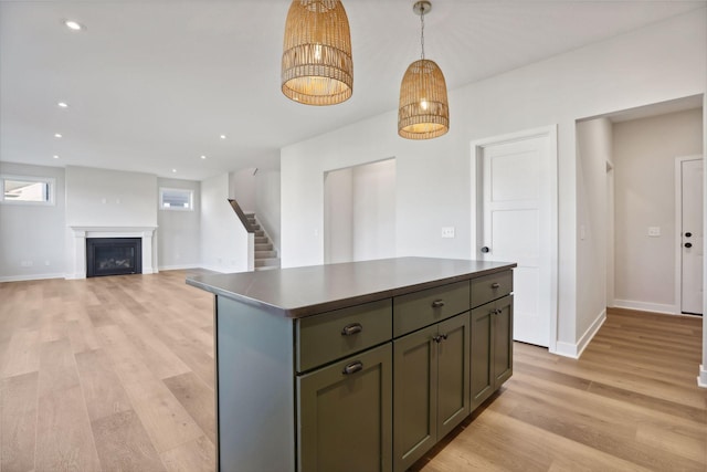 kitchen featuring decorative light fixtures, light hardwood / wood-style floors, and a kitchen island