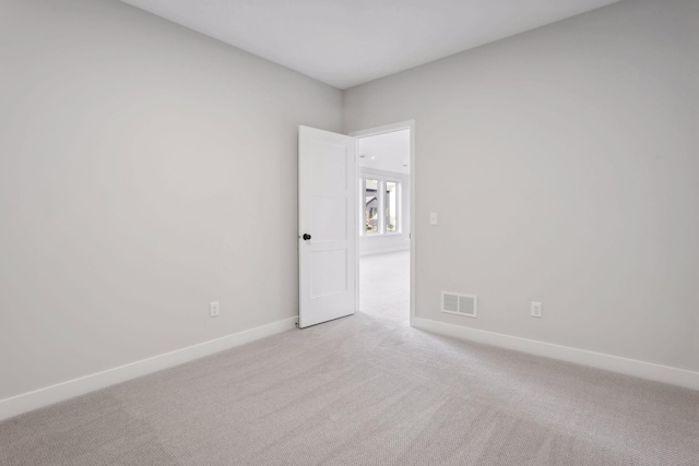 spare room featuring light colored carpet