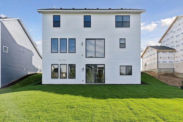 rear view of property featuring a lawn