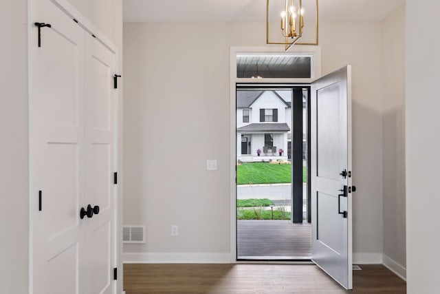 entryway featuring wood-type flooring and an inviting chandelier