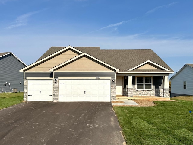 craftsman-style house featuring a garage, a front yard, and cooling unit