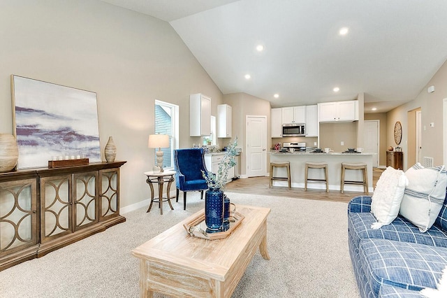 carpeted living room featuring high vaulted ceiling