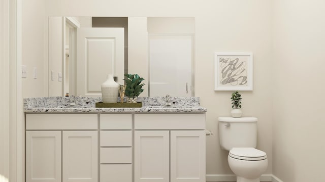 full bath featuring baseboards, double vanity, a sink, and toilet