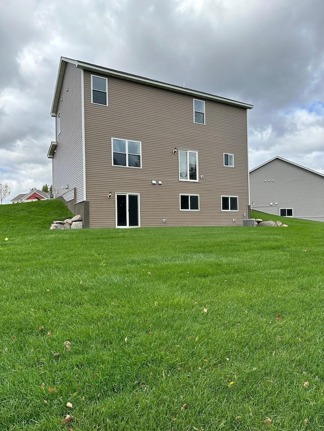 rear view of property featuring a lawn