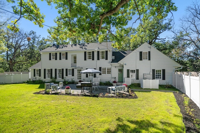 rear view of property with a yard and a patio area