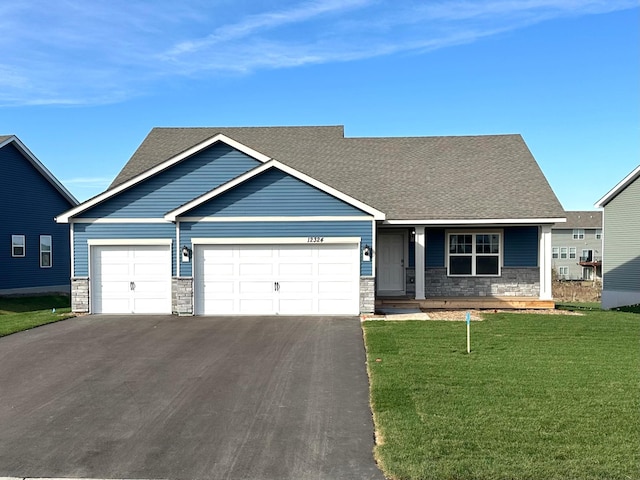 craftsman house featuring a garage and a front lawn