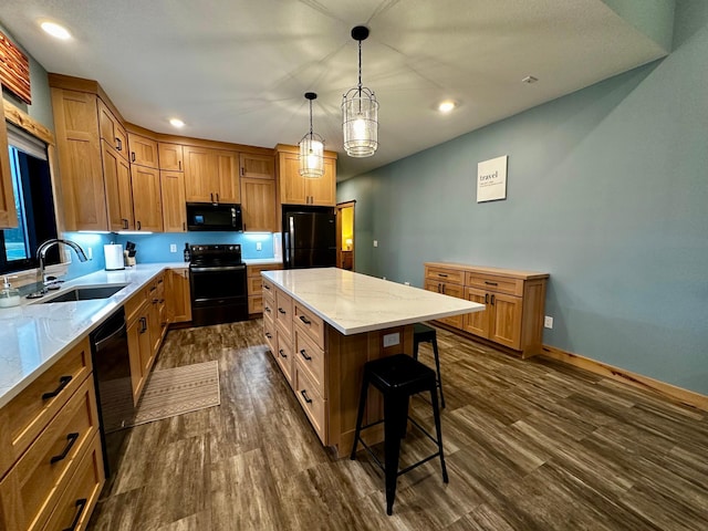 kitchen featuring sink, a center island, hanging light fixtures, dark hardwood / wood-style floors, and black appliances