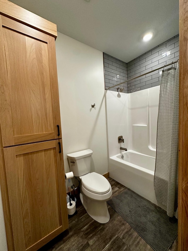 bathroom featuring hardwood / wood-style floors, shower / tub combo with curtain, and toilet