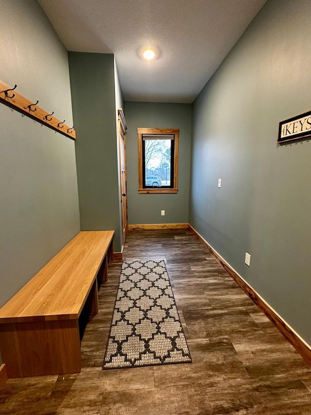 mudroom with dark wood-type flooring and a textured ceiling