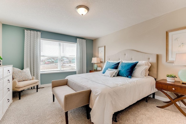 bedroom featuring light colored carpet and a textured ceiling