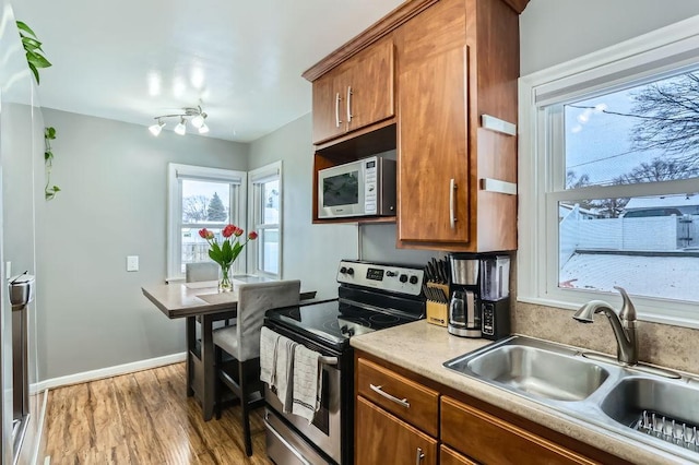 kitchen featuring stainless steel appliances, sink, and light hardwood / wood-style flooring