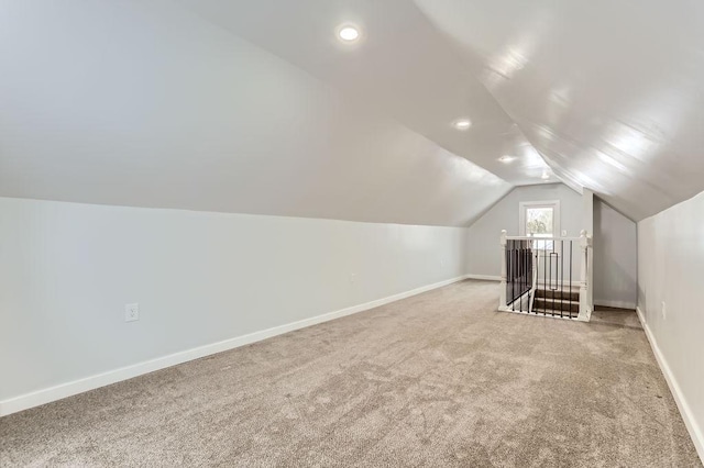 bonus room featuring vaulted ceiling and carpet flooring