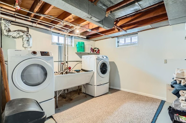 laundry room featuring plenty of natural light, sink, and washer and clothes dryer