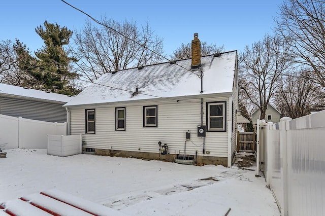 view of snow covered rear of property