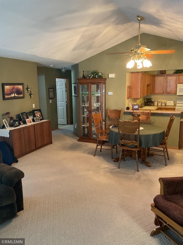 carpeted dining area featuring vaulted ceiling and ceiling fan