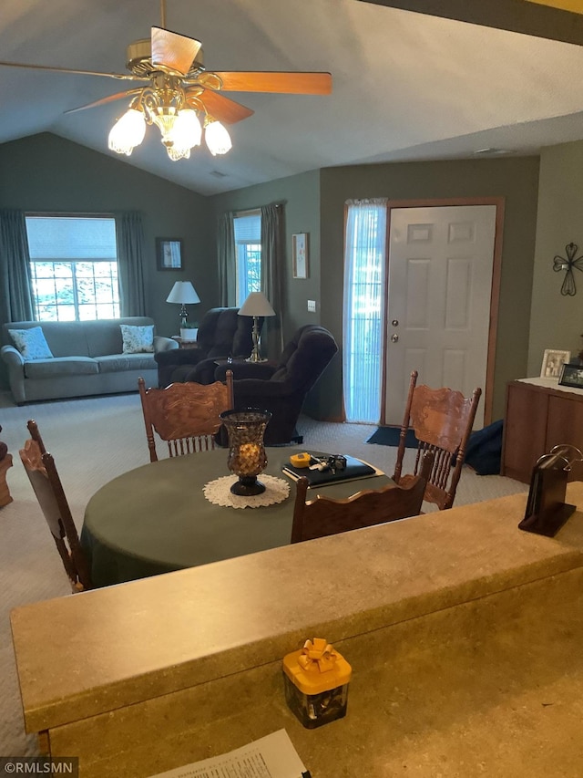 dining room with ceiling fan, carpet floors, and vaulted ceiling