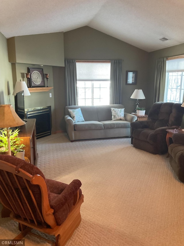 carpeted living room featuring lofted ceiling and plenty of natural light