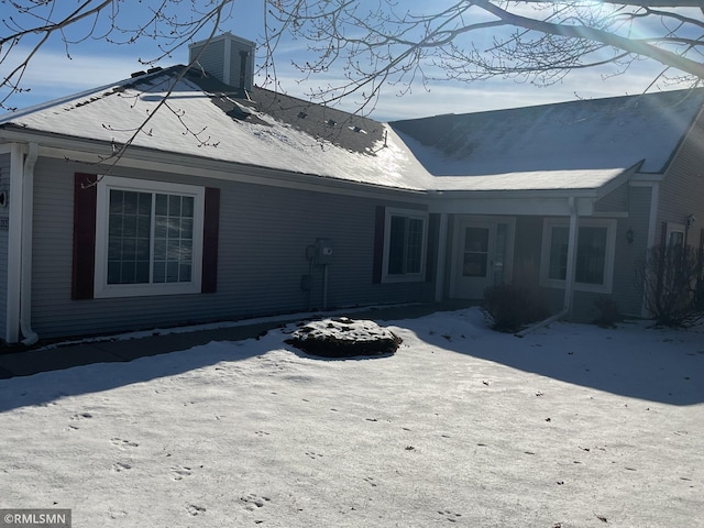 view of snow covered rear of property