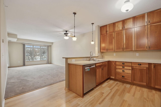 kitchen with dishwasher, brown cabinets, open floor plan, a peninsula, and light countertops