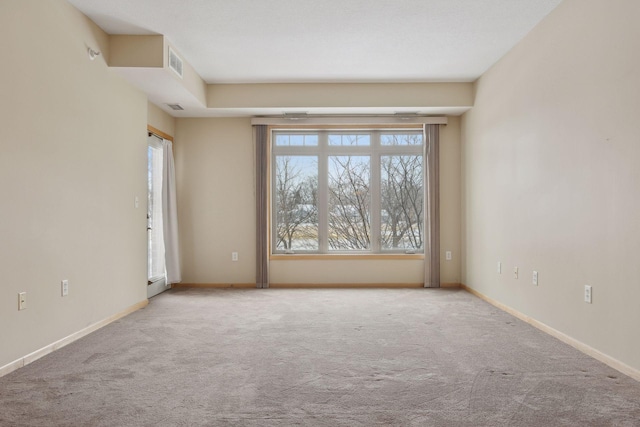 unfurnished room featuring visible vents, light carpet, and baseboards