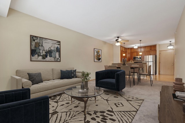 living area featuring light carpet and a ceiling fan